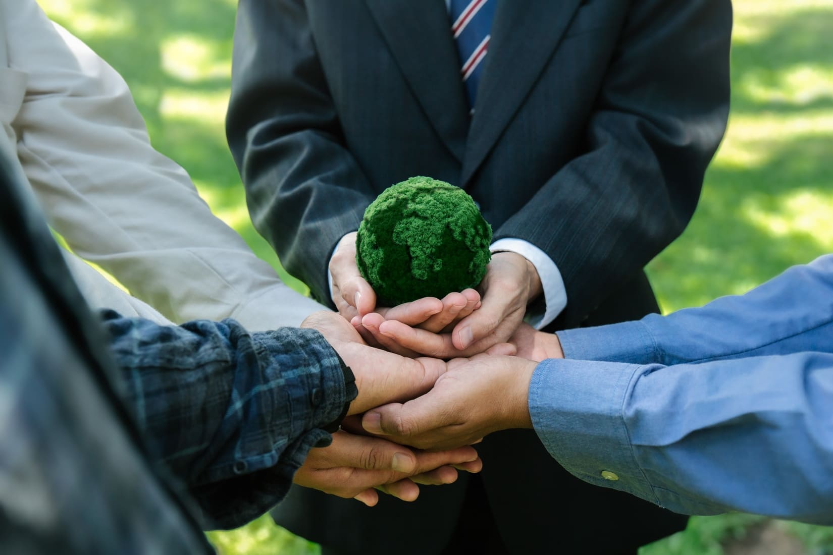 Mains réunies autour d'une terre verte illustrant l'offre RSE de TEEO